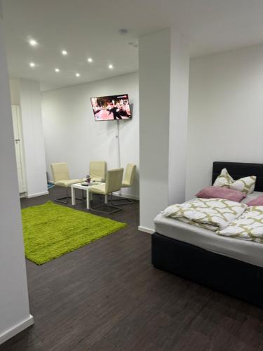um quarto com uma cama e uma televisão na parede em Luxuriöse Wohnung mit eigenem Garten em Augsburg