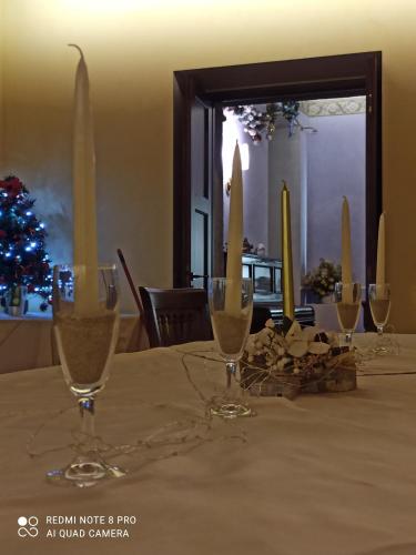 a table with three wine glasses and a christmas tree at B&B Il Casone di Drusa in San Marco dei Cavoti