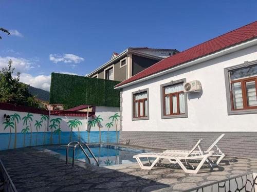 a swimming pool with a chair next to a house at Miracle Gabala villa in Gabala