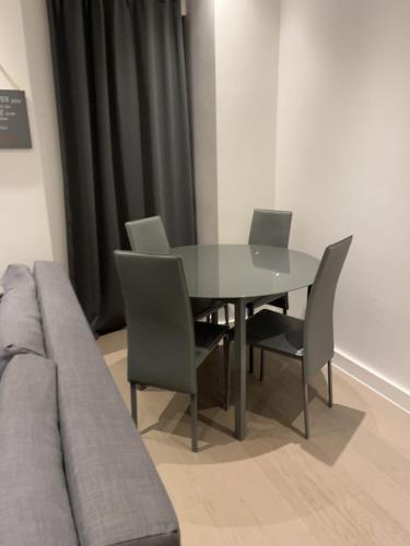 a dining room table with chairs and a couch at Maplewood properties - One bedroom luxurious apartment - Elm in Saint Albans