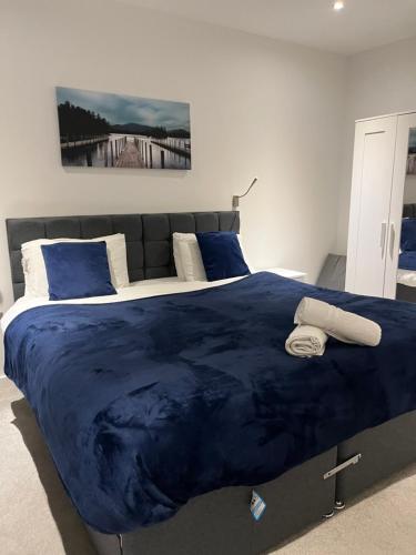 ein Schlafzimmer mit einer großen blauen Bettdecke auf einem Bett in der Unterkunft Maplewood properties - One bedroom luxurious apartment - Elm in St Albans