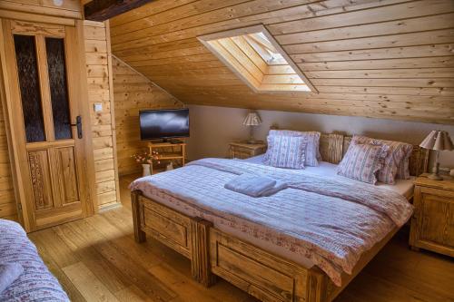 a bedroom with a large bed in a wooden room at Penzión Zbojnícky Halaš in Tisovec