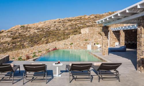 a group of chairs sitting next to a swimming pool at Villa ANAIS 2 MYKONOS in Elia Beach