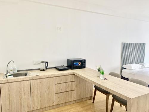 a kitchen with a counter with a sink and a bed at Deco Home @ Aru Suites in Kota Kinabalu