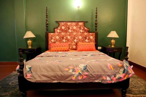 a bedroom with a large bed with orange pillows at Heritage Home in Central Kolkata in Kolkata