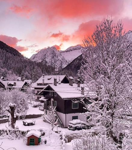 a house covered in snow with mountains in the background at Appartamento vista Monte Rosa, giardino in Residence Walser a 10minuti da Macugnaga - MONTEROSAFLAT in Vanzone
