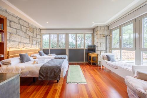 a bedroom with two beds and a stone wall at VentuRural in Venturada