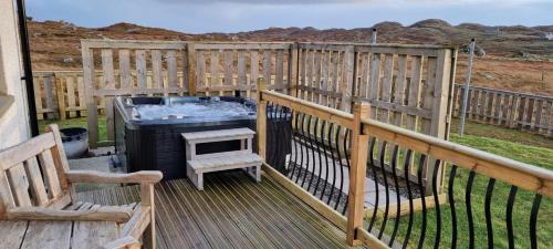 a deck with a hot tub and a grill at An Lochan in Manish