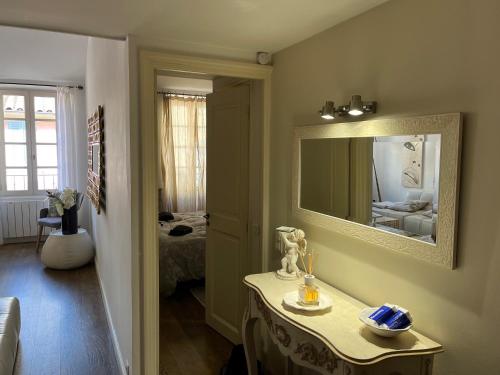 サントロペにあるAppartement trois pièces Saint Tropezの鏡、テーブル、ベッドが備わる客室です。