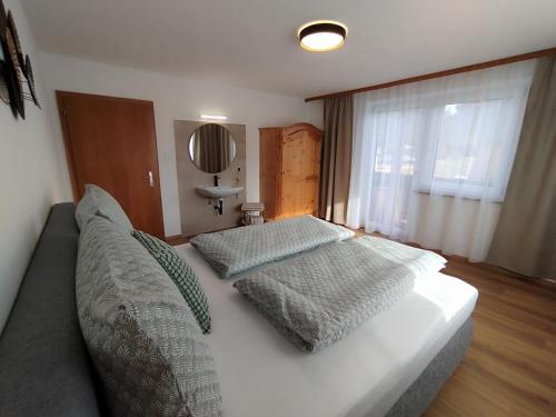 a bedroom with a bed with two pillows on it at Carina's Apartment in Obsteig