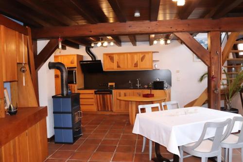 - une cuisine avec une table blanche et une cuisinière dans l'établissement Le DorliSchopf gîte 2 étoiles, à Dorlisheim