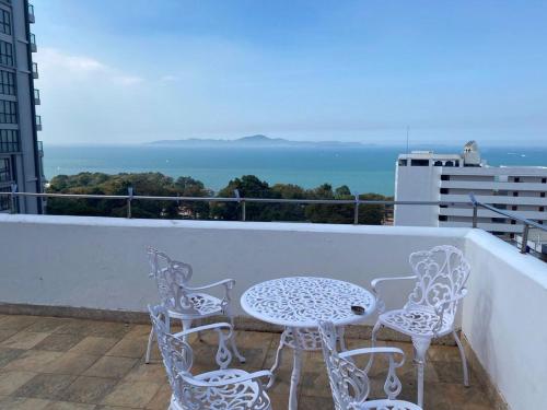 a table and chairs on a balcony with the ocean at Casa Espana in Pattaya South
