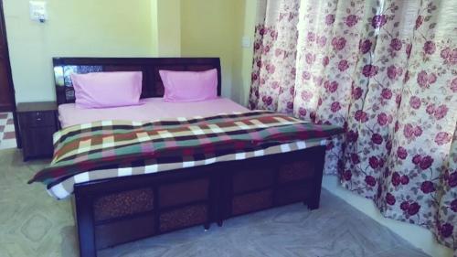 um quarto com uma cama com almofadas e cortinas cor-de-rosa em The Breeze Homestay em Shimla