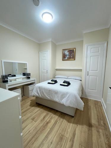 a bedroom with a bed and a desk in it at Station Lodge in London