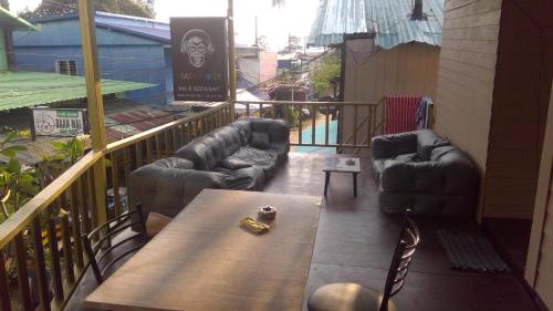a balcony with couches and a table and chairs at Crazy Monkey in Trat