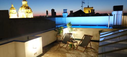 Un balcón con dos sillas y una mesa en un edificio. en San Luis Downtown & Pool Apartment, en Sevilla