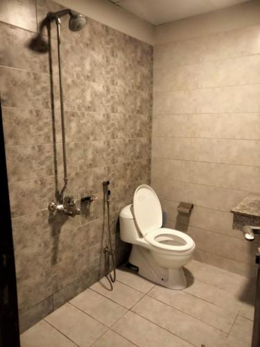 uma casa de banho com um WC e um chuveiro em Pine Heights Luxury Apartment em Islamabad