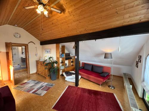 sala de estar con sofá rojo y techo de madera en Studioferienwohnung Bad Camberg, en Bad Camberg