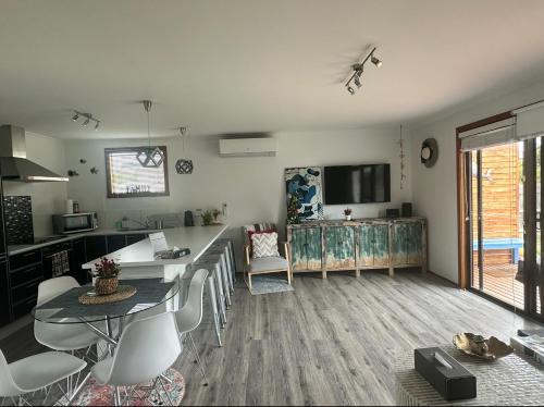 eine Küche und ein Wohnzimmer mit einem Tisch und Stühlen in der Unterkunft OwLHouse on Island in Cowes