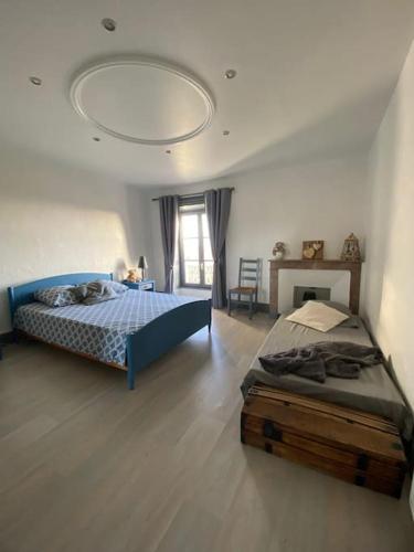 - une chambre avec un lit bleu et une table dans l'établissement L'échappée verte, à Champdieu