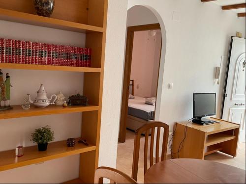 een kamer met een tafel en een bureau met een computer bij Gran Alicante Bungalow in Beach Resort in Puerto Marino