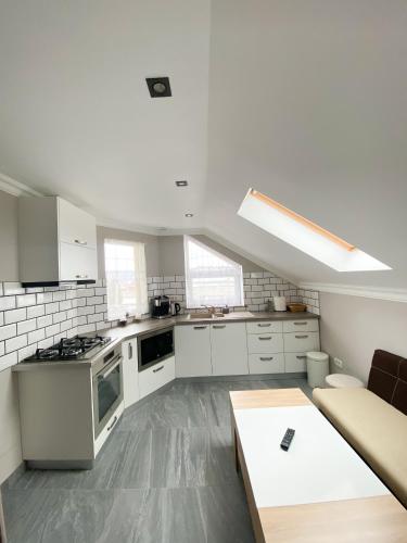 a kitchen with white cabinets and a couch and a table at One Room Studio in Râşnov