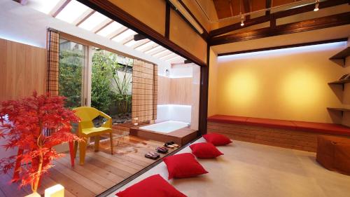 a living room with a yellow chair and red pillows at Open-air bath/11 mins walk from Hakone Yumoto Sta. in Hakone