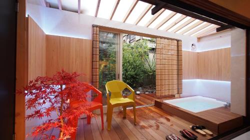 a bathroom with a yellow chair and a tub at Open-air bath/11 mins walk from Hakone Yumoto Sta. in Hakone