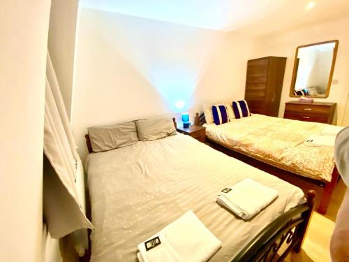 a small bedroom with two beds and a mirror at One Bedroom Apartment in Ealing Broadway London in Ealing