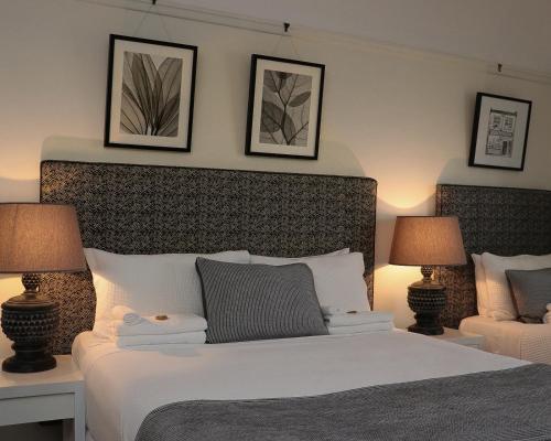 a bedroom with a white bed with two lamps at Edward Lodge New Fam in Brisbane
