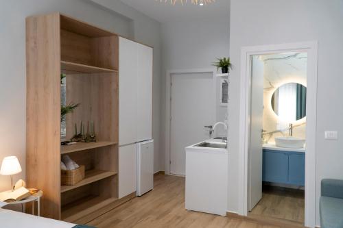 een witte badkamer met een wastafel en een spiegel bij Oyster Apartments in Sarandë