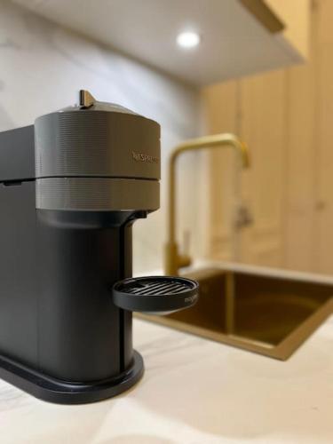 une cafetière posée sur un comptoir à côté d'un évier dans l'établissement Studio Chic Montmartre Opéra, à Paris