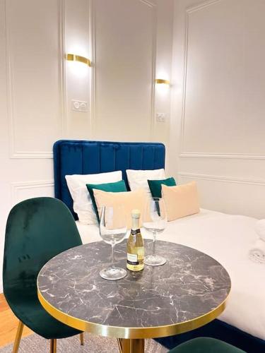 - une table avec 2 verres à vin au-dessus d'un lit dans l'établissement Studio Chic Montmartre Opéra, à Paris