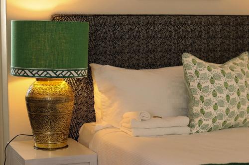 a bed with a green lamp and a pile of towels at Edward Lodge New Fam in Brisbane