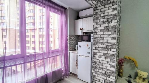 een keuken met een paars raam en een koelkast bij Миниотель в Харькове, ЮЖД in Charkov