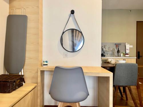 a mirror on a wall above a table with a chair at Hush Inn at K Avenue Kota Kinabalu in Kota Kinabalu