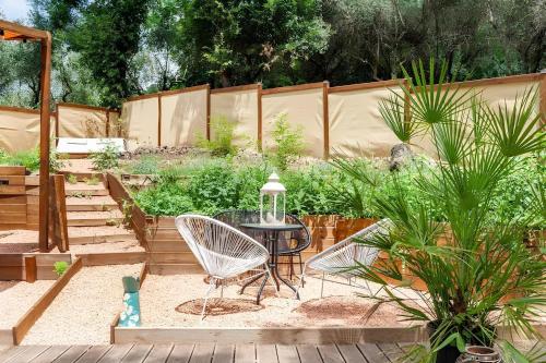 a patio with a table and chairs in a garden at Ganzo - Tuscany Retreat in Massarosa