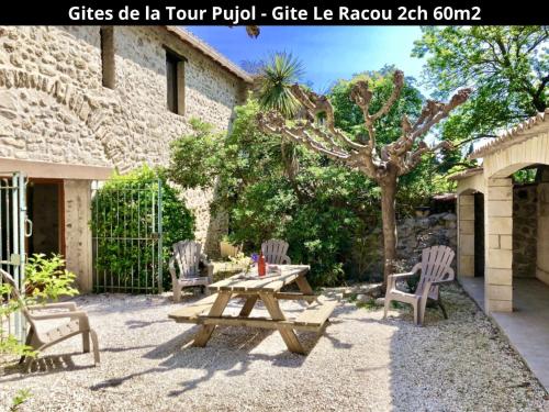 stół piknikowy i dwa krzesła na dziedzińcu w obiekcie Les Gîtes de la Tour Pujol w Argelès-sur-Mer