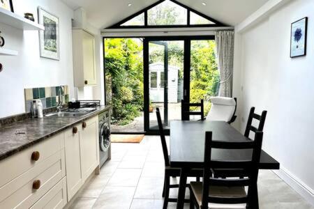 a kitchen with a table and chairs and a dining room at Charming 1 bed super central Terraced House in Cambridge