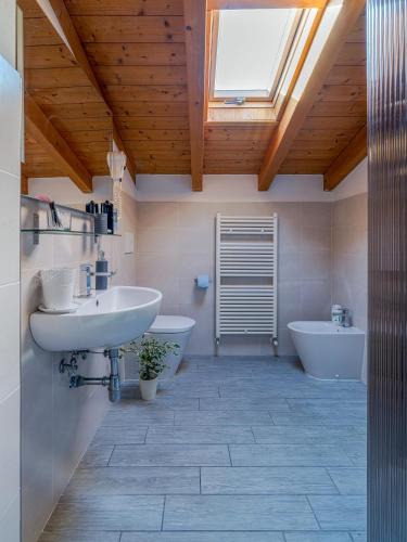 a bathroom with a sink and two toilets and a skylight at House Sabbioneta in Sabbioneta