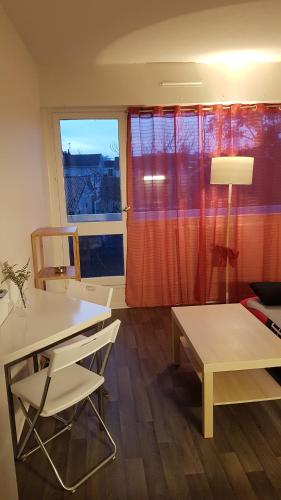 Cette chambre comprend un bureau, une table et une fenêtre. dans l'établissement Agréable studio Bordeaux proche toutes commodités, à Bordeaux