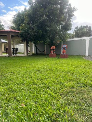 a yard with a house with a tree and a building at Villa Familiar con Piscina Privada y Rio in Bonao