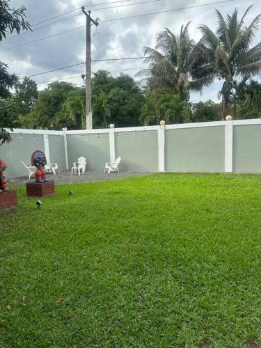 a yard with a white fence and some chairs at Villa Familiar con Piscina Privada y Rio in Bonao
