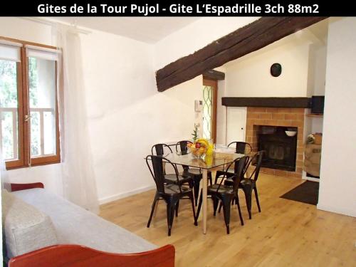 ein Esszimmer mit einem Tisch, Stühlen und einem Kamin in der Unterkunft Les Gîtes de la Tour Pujol in Argelès-sur-Mer