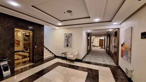 a hallway with a stairway with a chair and a table at Tulip Plaza Hotel in Hafr Al Baten