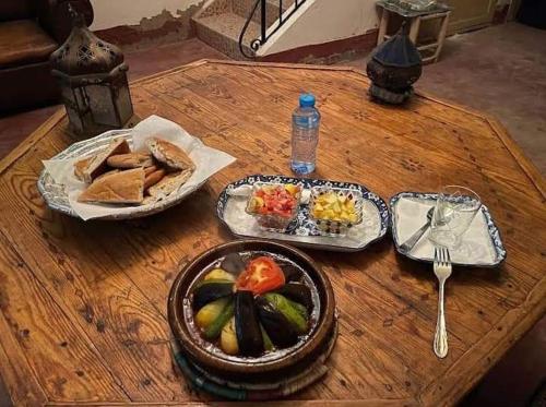 a wooden table with plates of food on it at Auberge Aain Nakhla in Guelmim