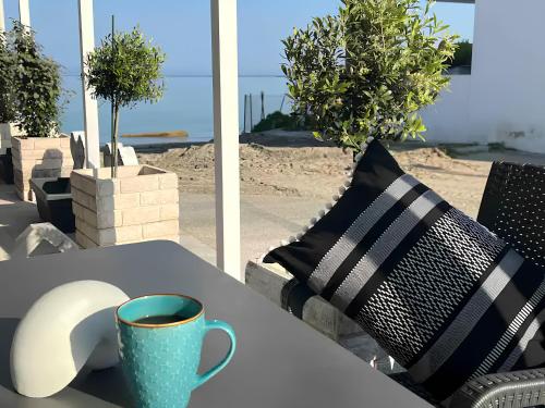 a table with a cup of coffee and a mouse on it at House by the sea suite 2 in Skála Foúrkas
