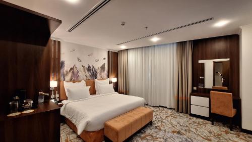 a hotel room with a bed and a desk and a desk at Tulip Plaza Hotel in Hafr Al Baten