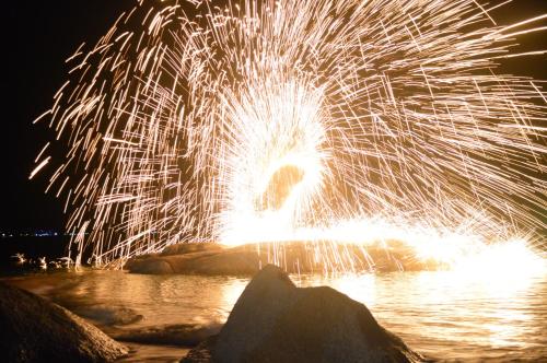 a firework display in the water at night at Bonny Hotel 4 Floors No Elevator in Lamai