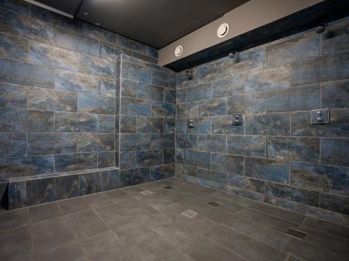 a large bathroom with a stone wall at Hotel We Wellness in Adendorf